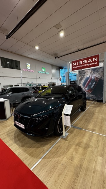 Digital display tablet stand showing car specifications at an auto expo.